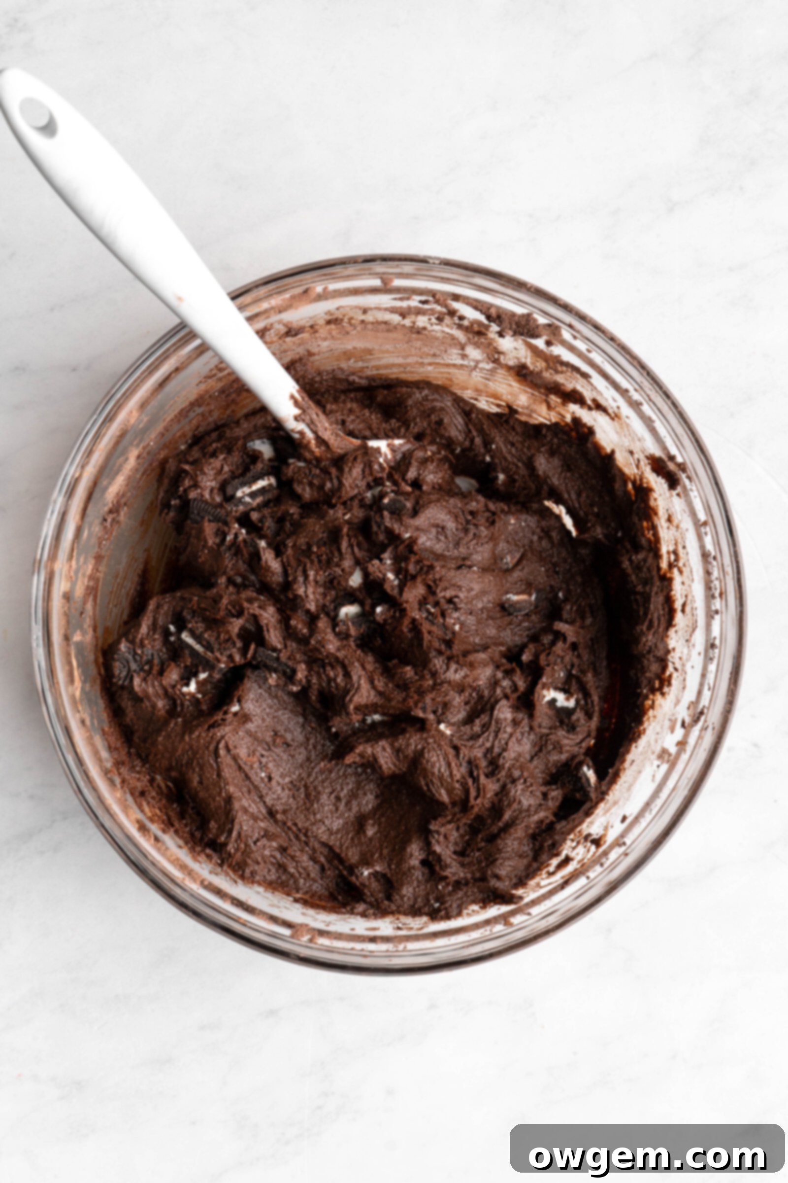 Rich Oreo SunButter Brownie batter in a mixing bowl with chopped Oreos folded in.