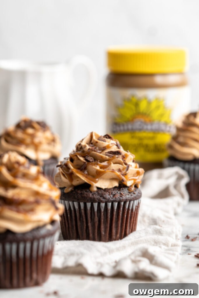Snicker chocolate cupcakes filled with peanut free SunButter caramel sauce, topped with caramel buttercream, caramel sauce and chocolate shavings