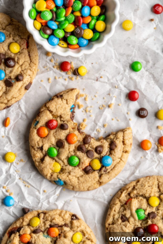 A perfectly baked peanut-free monster cookie with a bite taken out, revealing its chewy texture and colorful mix-ins.
