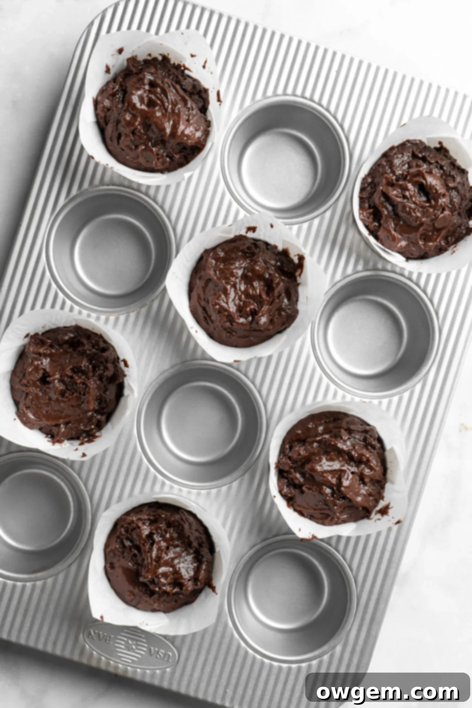 Bakery style double chocolate chip muffin batter, showing its rich, dark color and thick consistency.