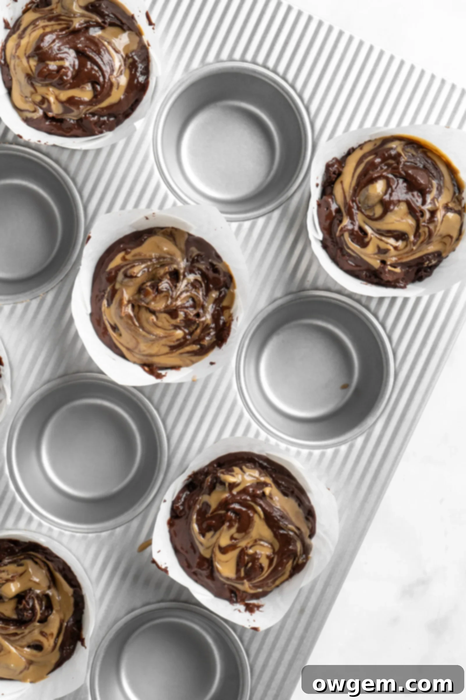 Sunbutter swirled into bakery style double chocolate chip muffin batter, showing the marbled effect.