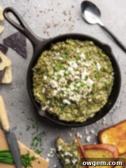Creamy bright green spinach dip and artichoke dip, topped with feta cheese and chives and served warm